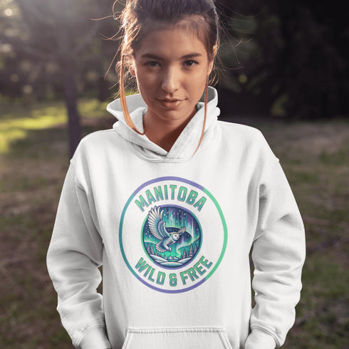 Embrace the magic of the prairies with our Manitoba – Wild & Free hoodie, featuring a captivating graphic of a snowy owl in flight beneath the shimmering northern lights.